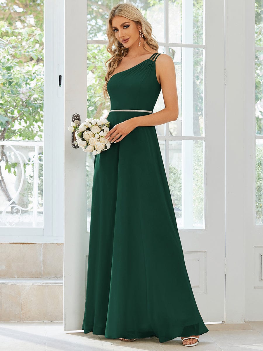 Model wearing a dark green flowy chiffon one-shoulder bridesmaid dress.