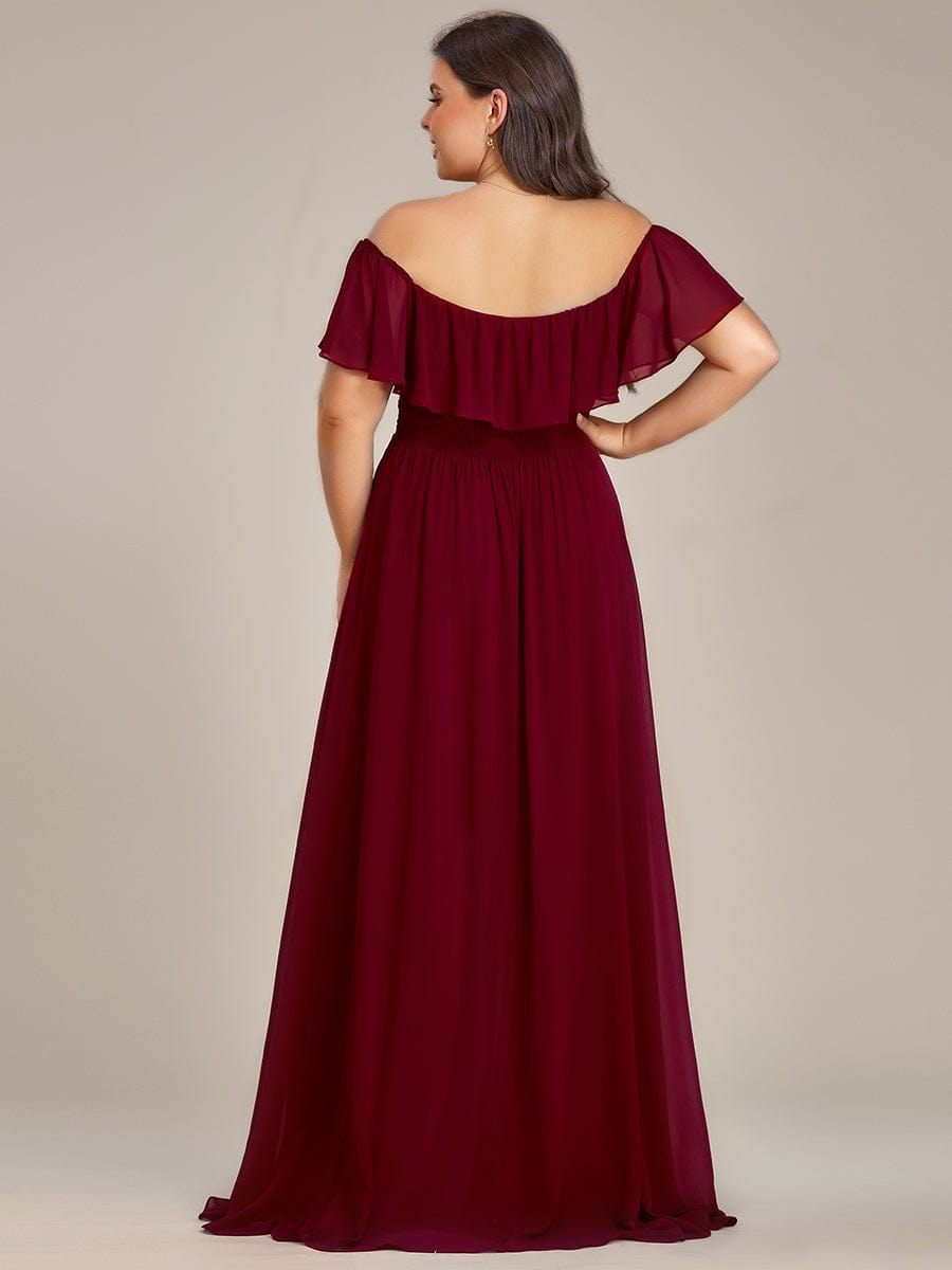 Side view of a plus size model in a blue off-shoulder high-low bridesmaid dress.
