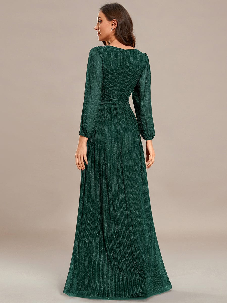 Side view of a model in a dark green glittery A-line evening dress.