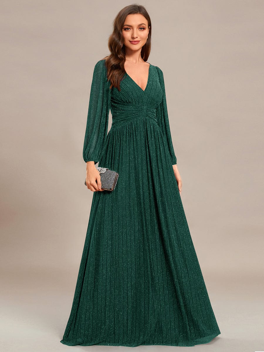 Full length view of a dark green glittery A-line evening dress.