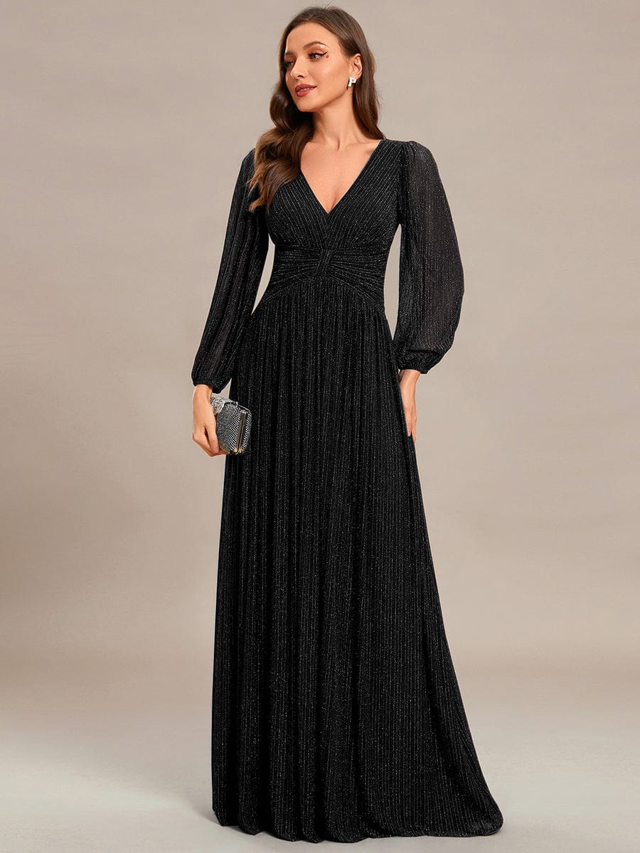 Model in a black glittery A-line empire waist evening dress.