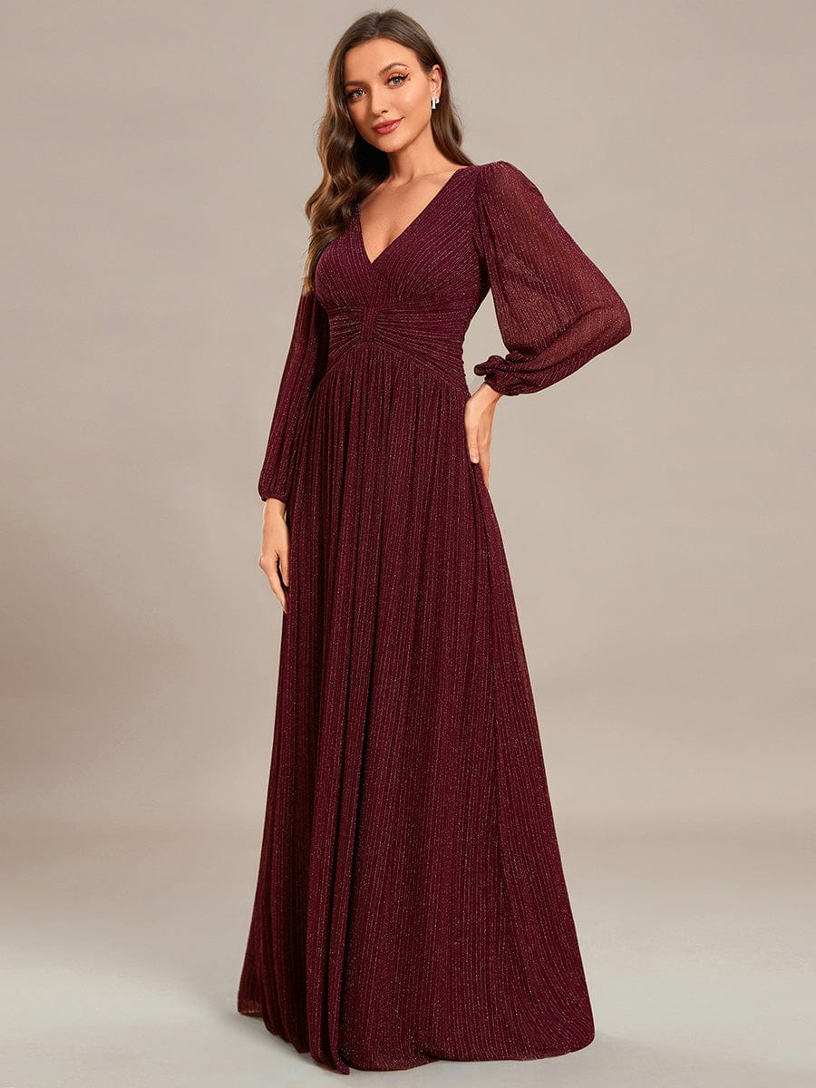 Model in a burgundy glittery A-line empire waist evening dress.
