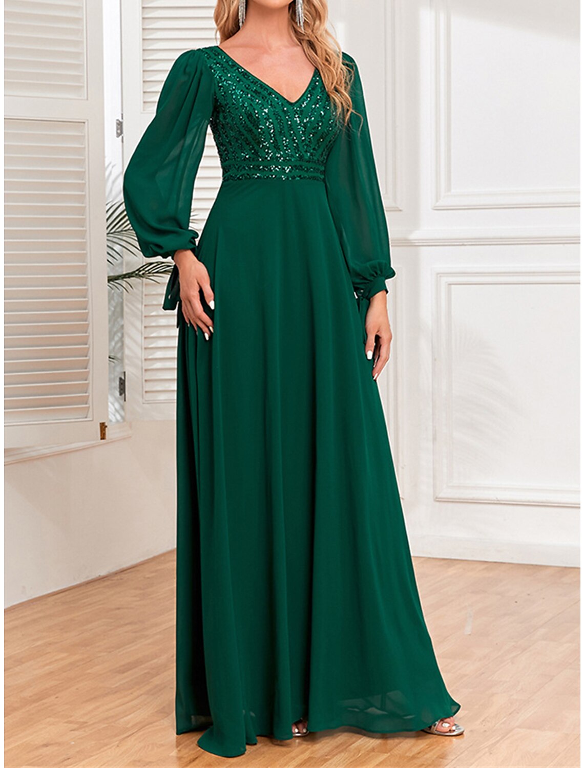 Woman walking in a shimmering green sequin evening gown.