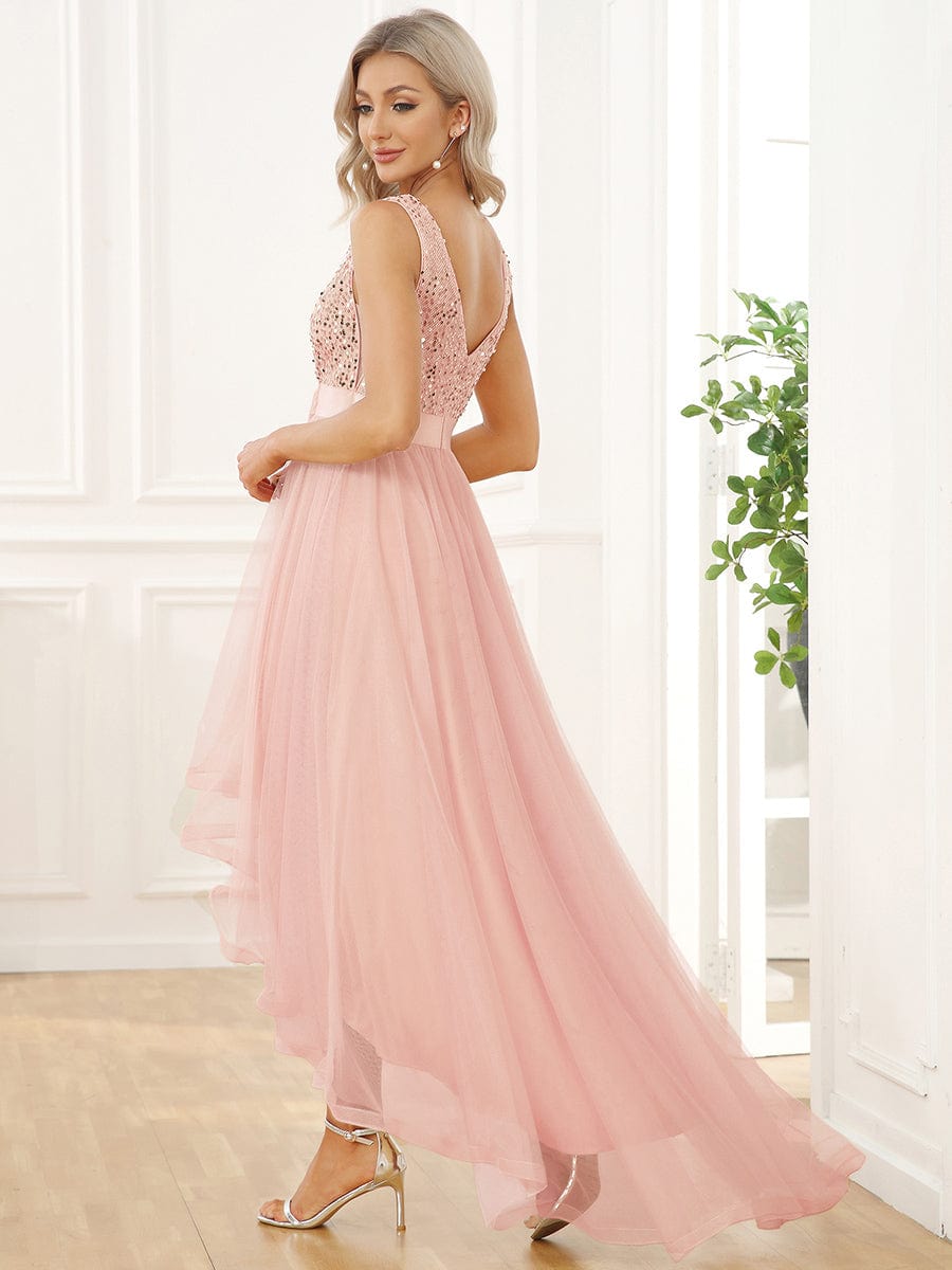 Side view of a woman wearing a pink sequin and tulle high-low dress.