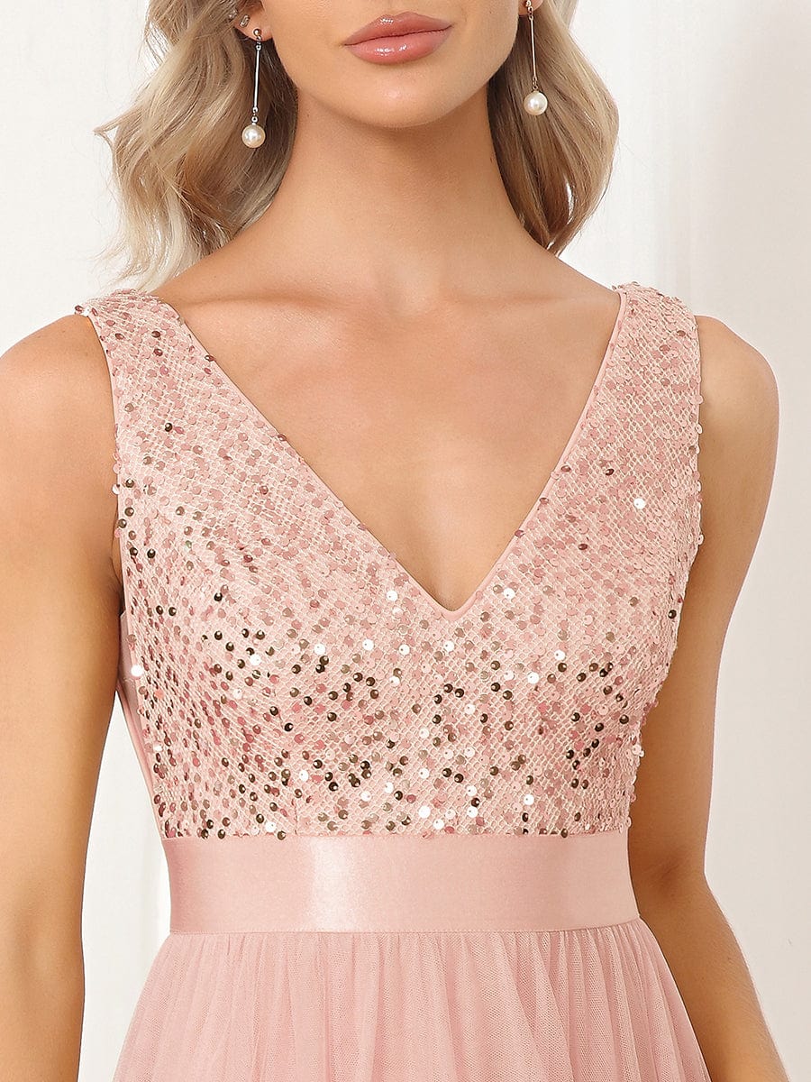 Back view of a woman in a pink sequin bodice high-low bridesmaid dress.