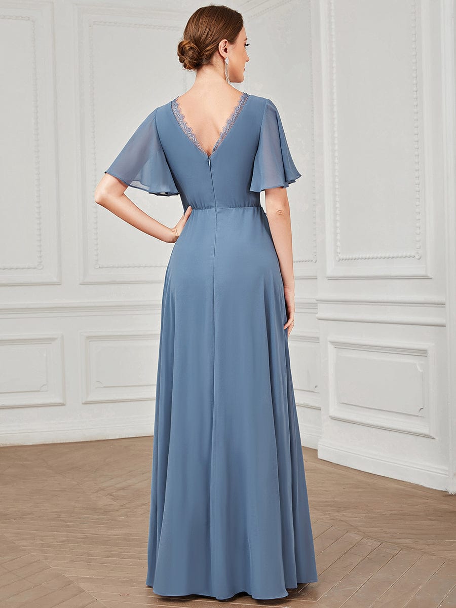 Side view of a woman in a navy blue A-line short sleeve bridesmaid dress.