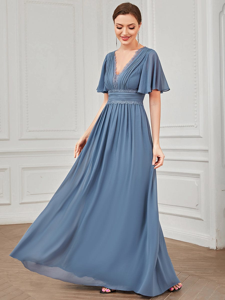 Woman posing elegantly in a navy blue A-line chiffon bridesmaid dress.