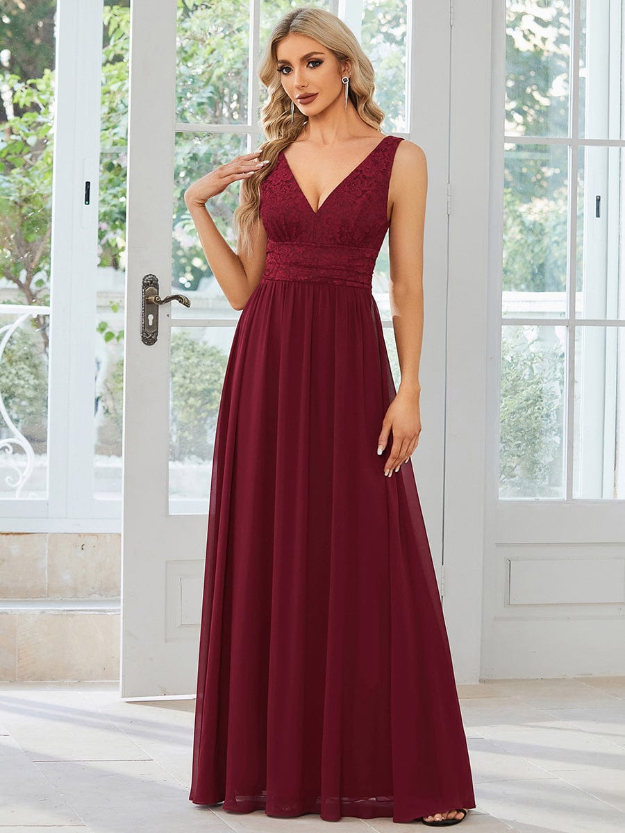 Side view of a model in a red empire waist chiffon gown.