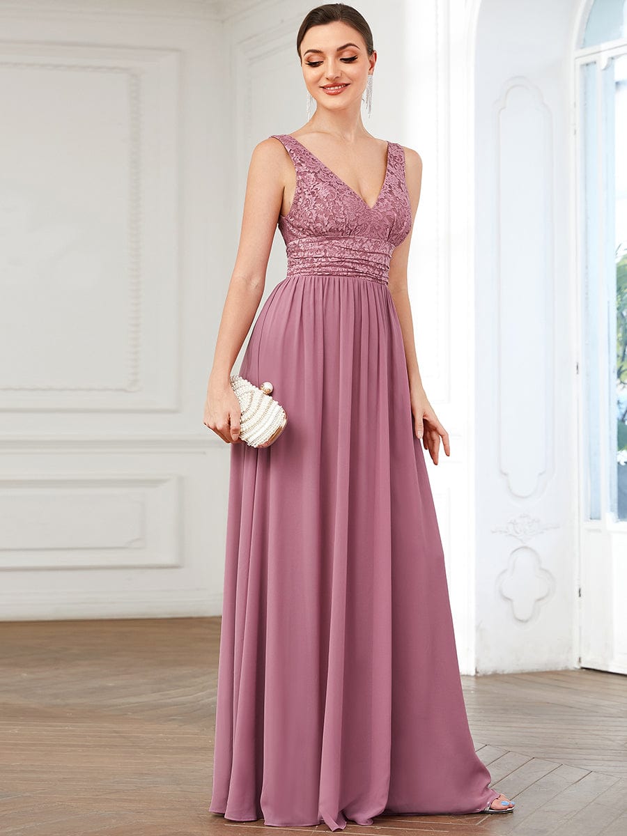 Model wearing a navy blue lace and chiffon empire waist V-back evening gown.