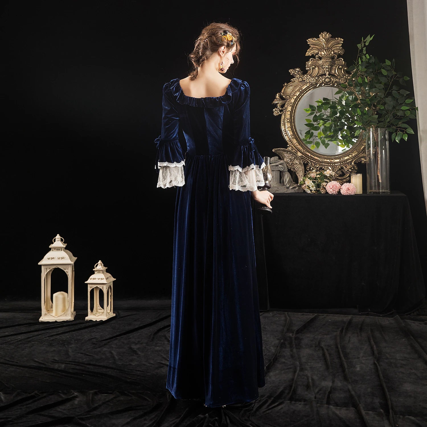 Full view of a woman in a dark Victorian-style party dress with a wide, flowing skirt.