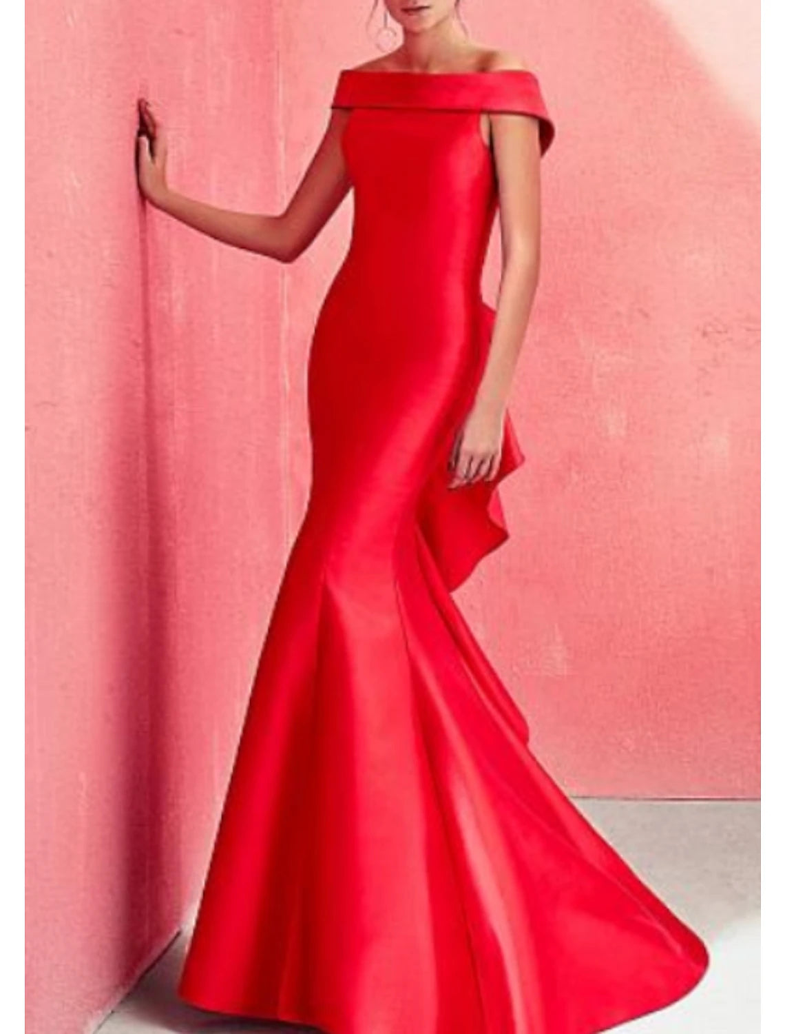Woman wearing a red mermaid off-shoulder formal evening dress with ruffles and draping.