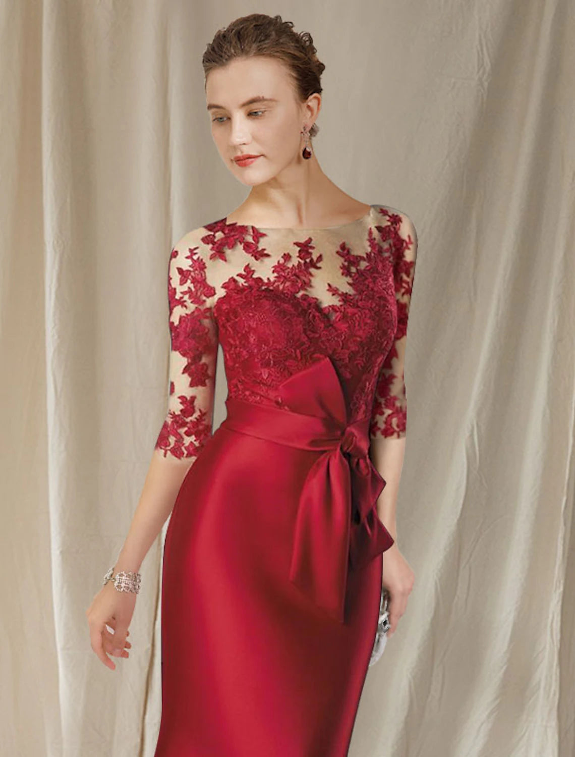 Back view of the floor-length satin lace gown with bow appliques.