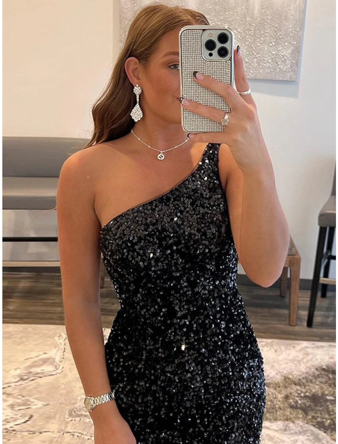 Side view of a model in a black sequined one-shoulder homecoming dress.