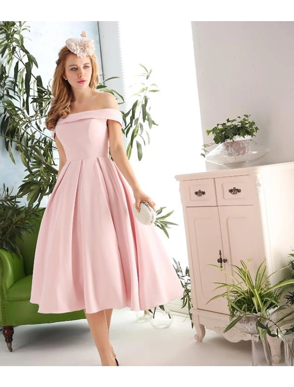 Close-up of navy cocktail dress showing pleated detail and off-shoulder neckline.