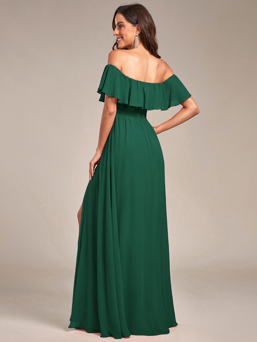 Side view of a woman in a dark green off-shoulder ruffle thigh slit A-line bridesmaid dress.