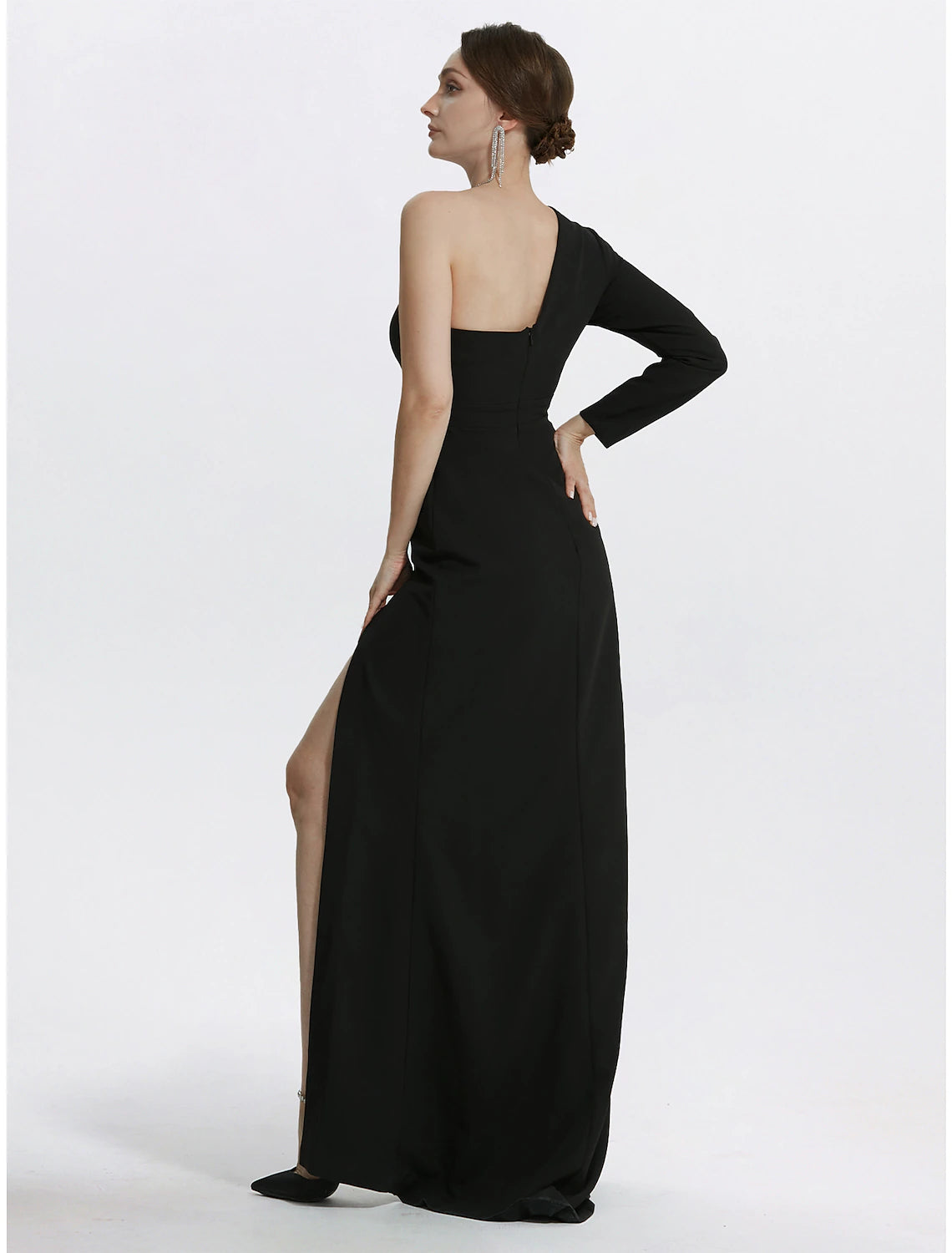 Back view of a woman in a black one-shoulder long sleeve mermaid dress.