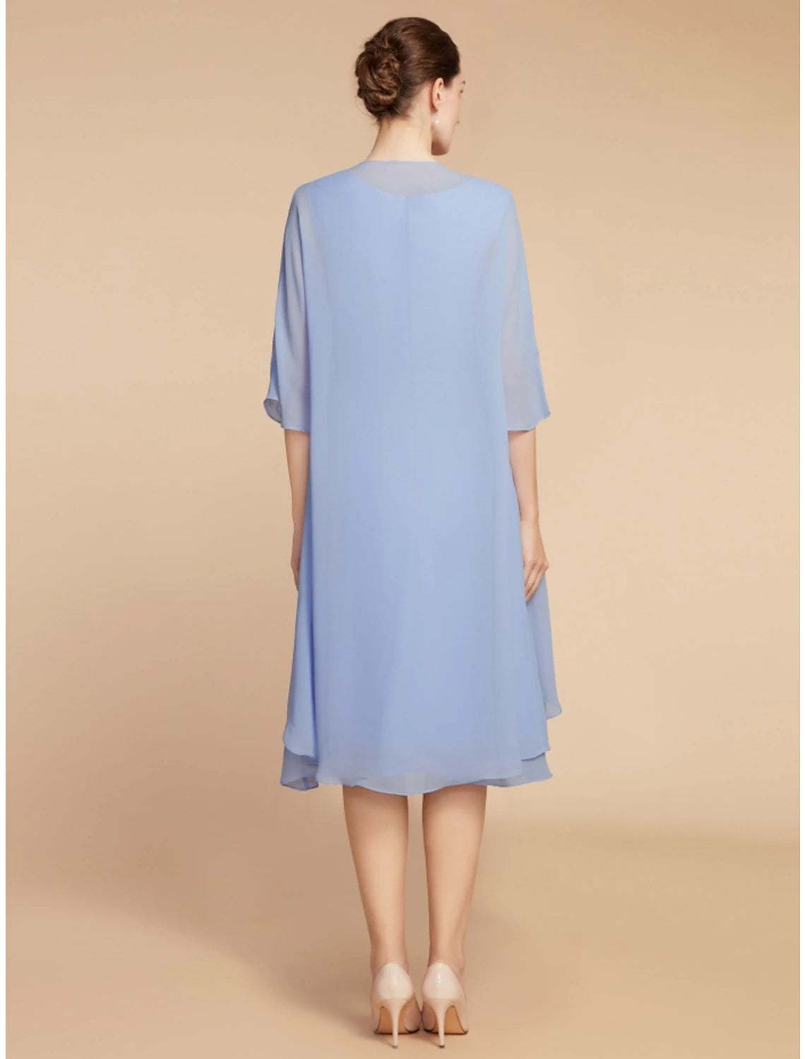 Side view of woman in ruched knee-length two-piece dress.