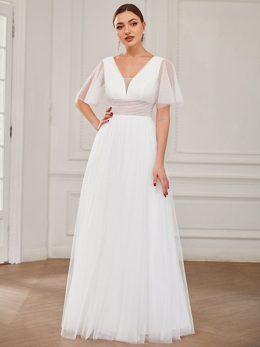 Model in a white pleated A-Line short sleeve tulle bridesmaid dress.