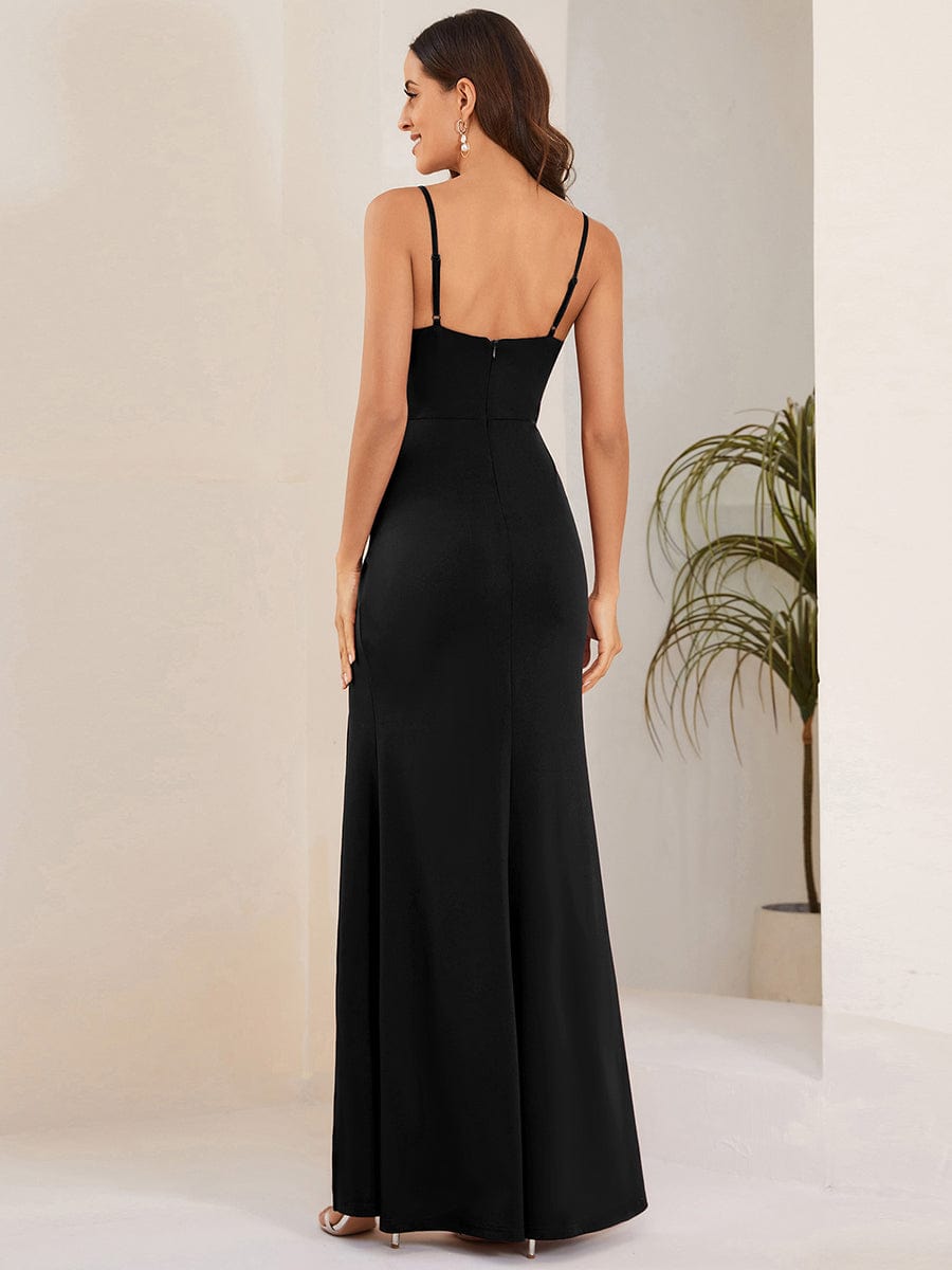 Back view of a woman wearing a black spaghetti strap evening gown.