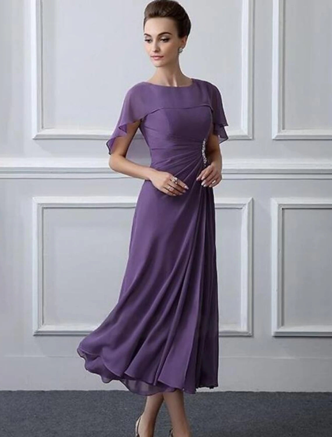 Close-up of crystal brooch and bateau neckline on the dress.
