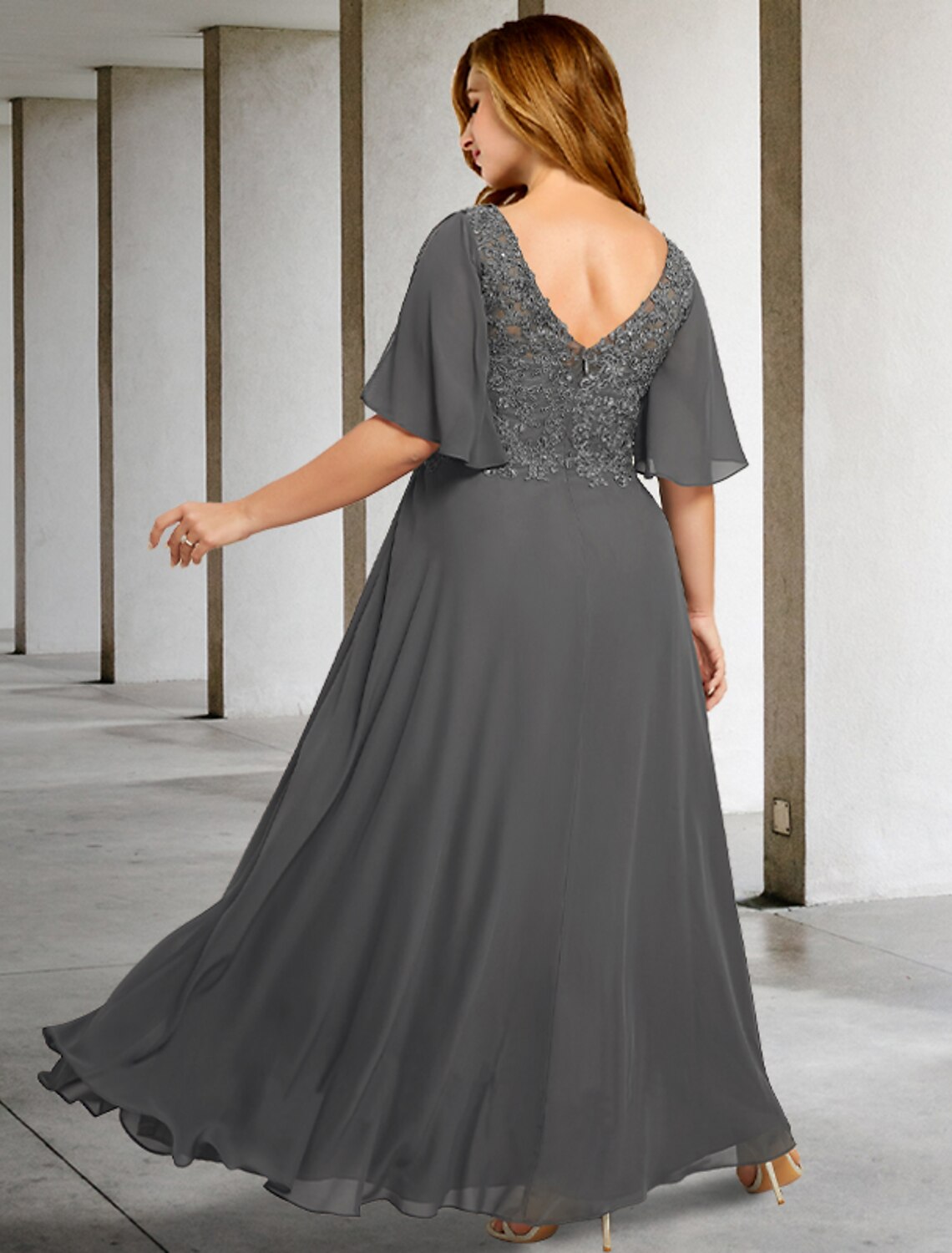 Elegant floor-length formal gown with pleats and appliques.
