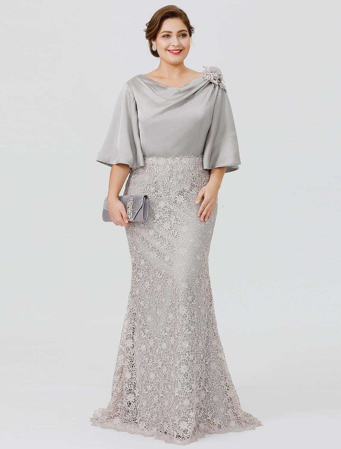 Full length view of a woman wearing an elegant plus size mermaid mother of the bride dress with a cowl neck and half sleeves.
