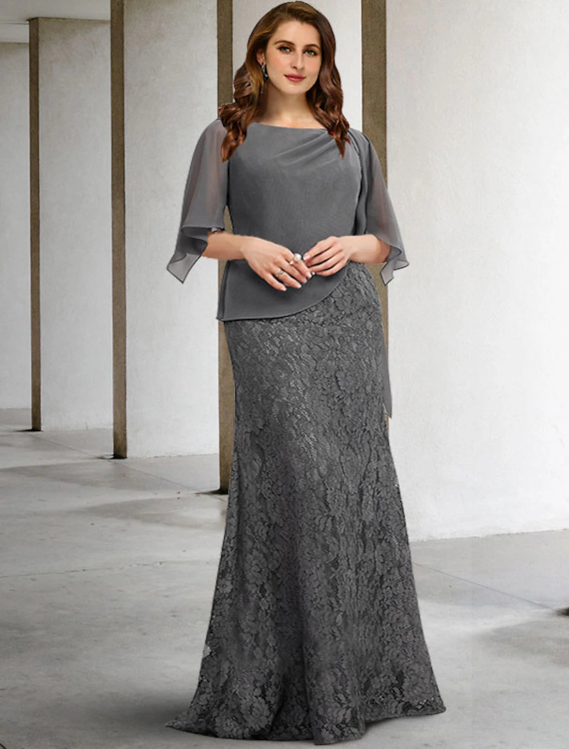 Woman wearing an elegant plus size sheath column mother of the bride dress with half sleeves and jewel neck.