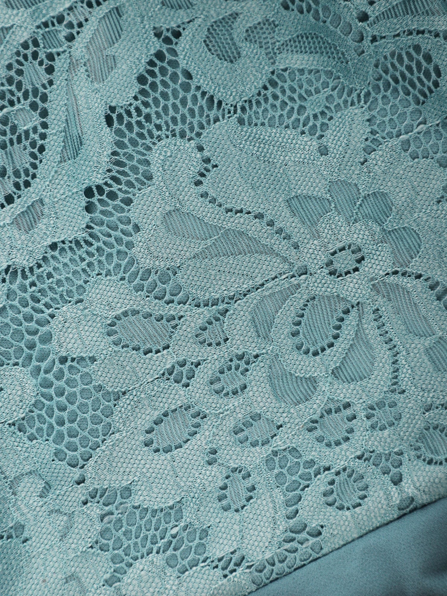 Close-up of the lace halter neckline and backless detail of a dark blue dress.