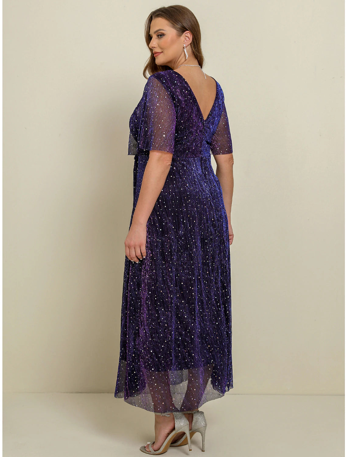 Side view of a woman in a purple plus size A-line maxi dress.