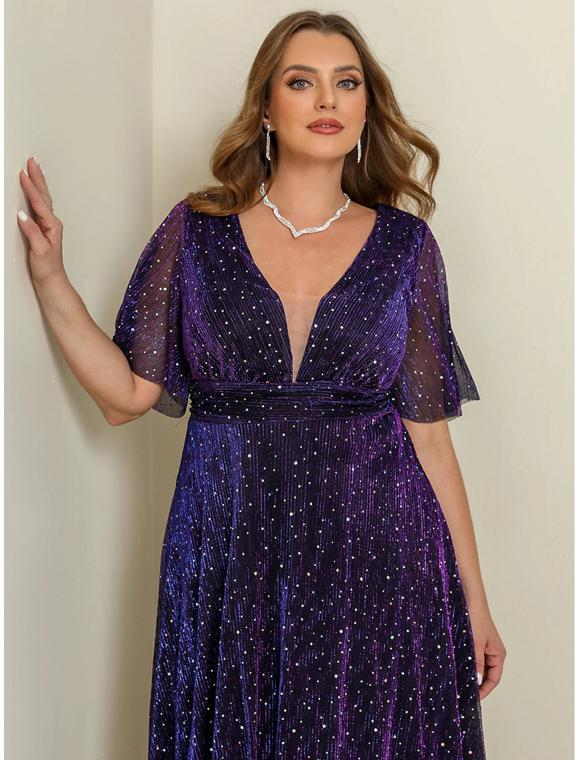 Back view of a woman in a flowing purple plus size maxi dress.