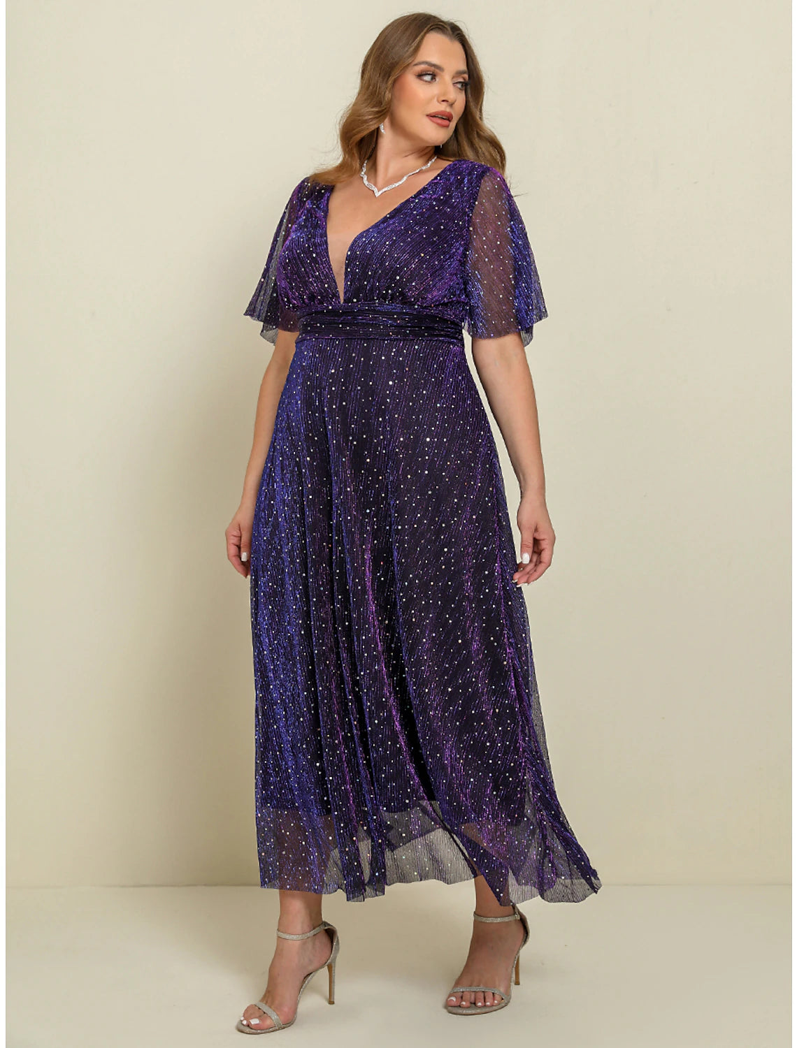 Woman posing in a purple plus size A-line maxi dress, showing movement.