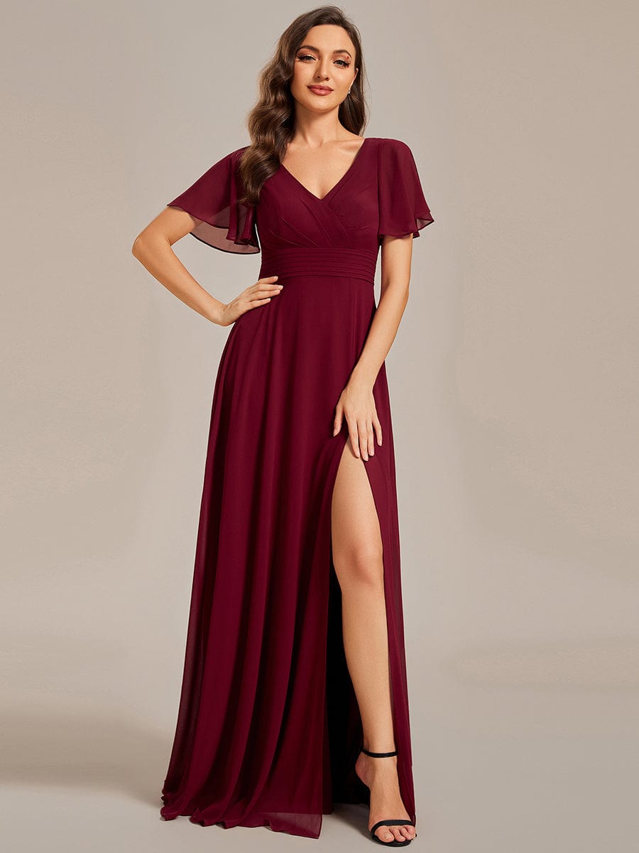 Woman wearing a red A-line evening dress with swing collar and ruffle sleeves.