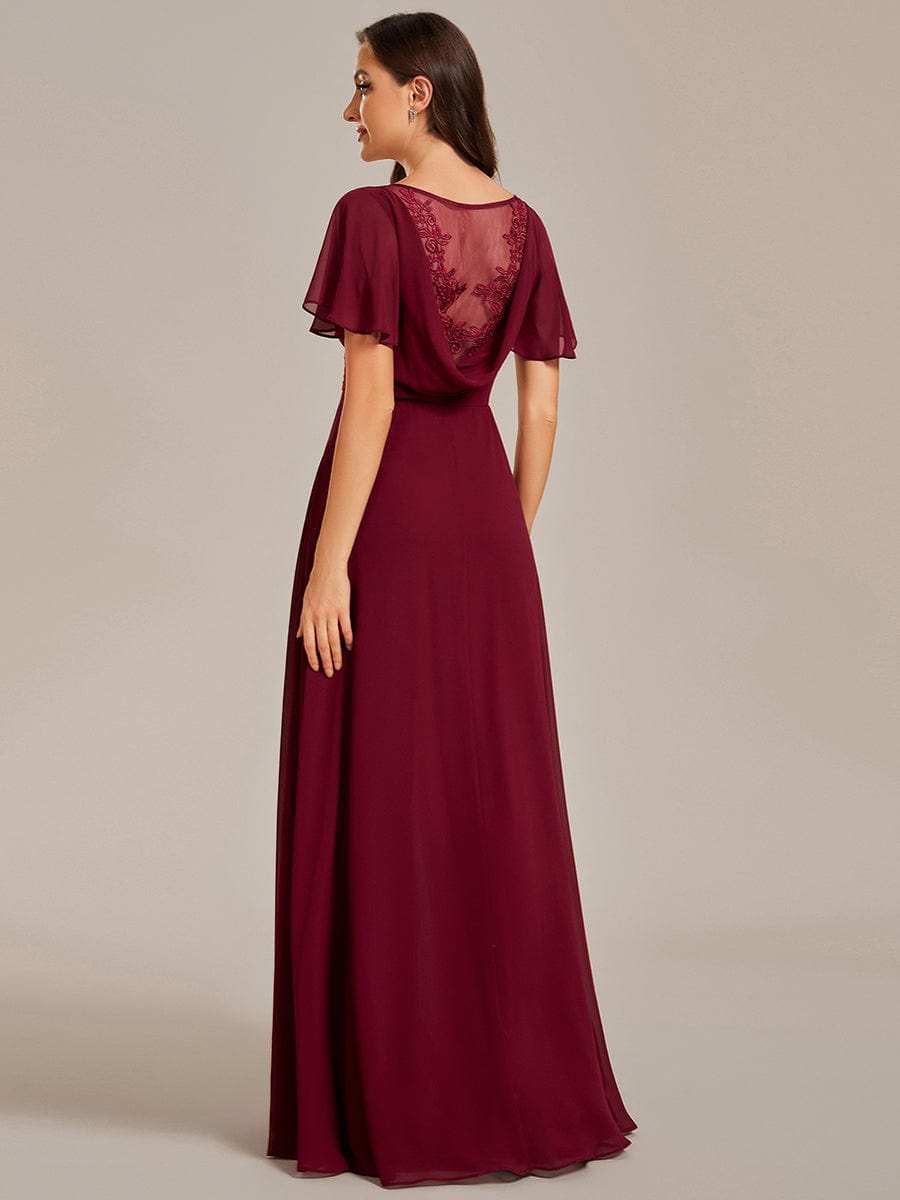 Side view of the red A-line evening dress, showing ruffle sleeves and flowing skirt.
