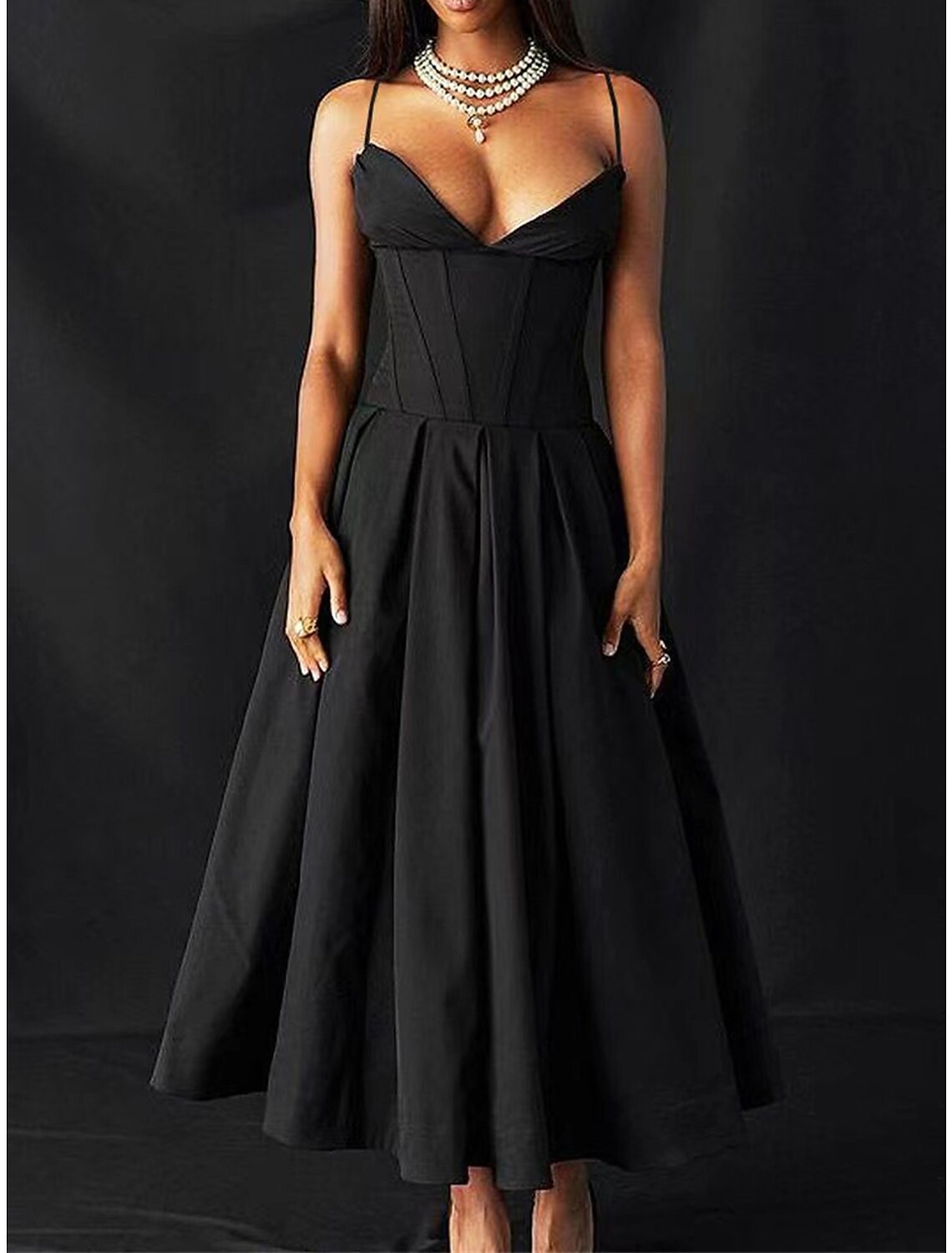 Model wearing a black ruched spaghetti strap maxi dress, front view.