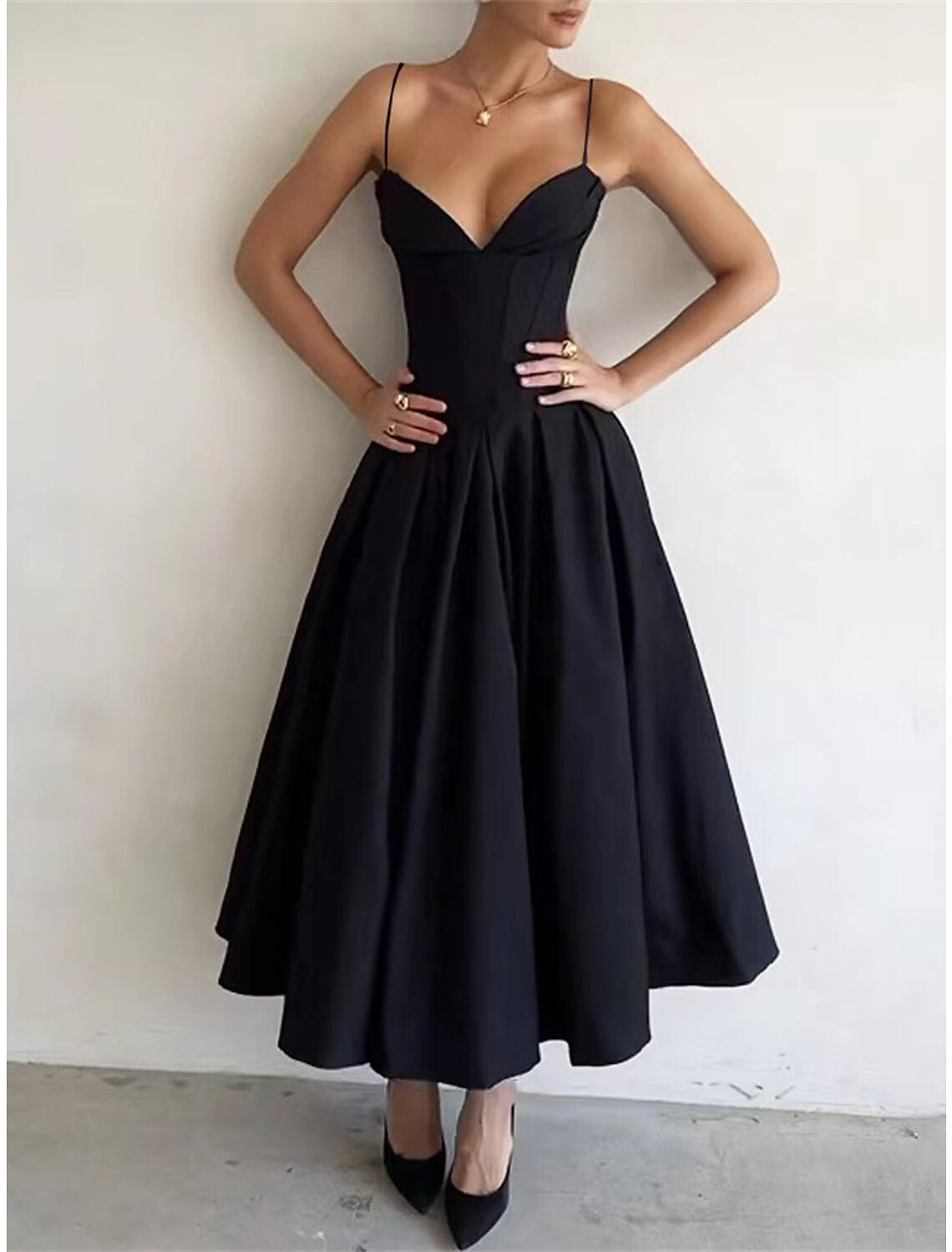 Model wearing a black ruched spaghetti strap maxi dress, back view.