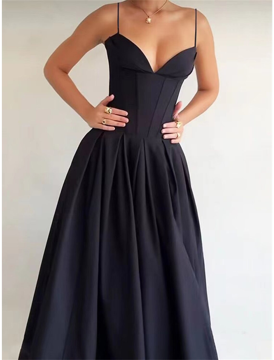 Close-up of the ruched detail on a black spaghetti strap maxi dress.