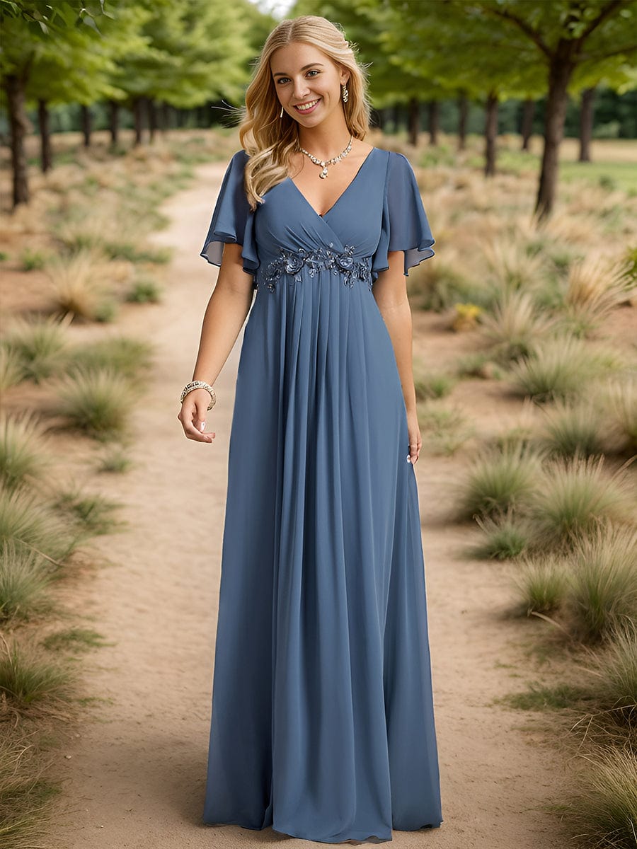 Woman wearing a dark blue Weitese A-line maxi evening dress with ruffles sleeves and waist applique.