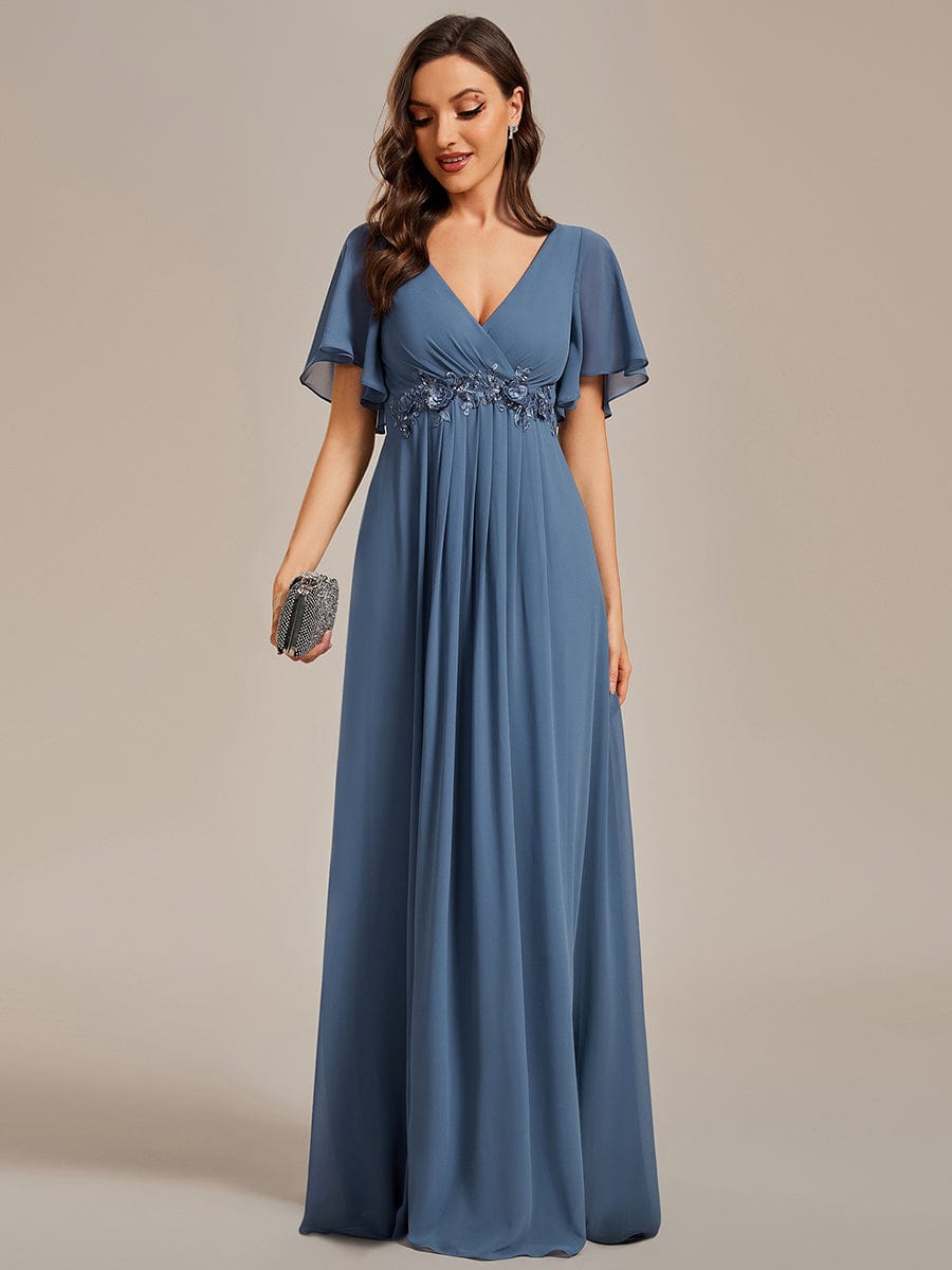 Close-up of the waist applique and ruffles sleeve on a dark blue Weitese evening dress.