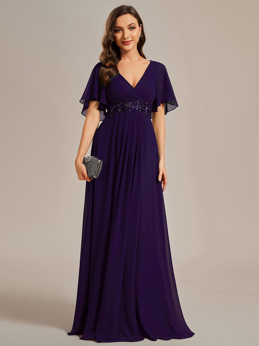 Woman wearing a dark purple Weitese A-line maxi evening dress with ruffles sleeves.