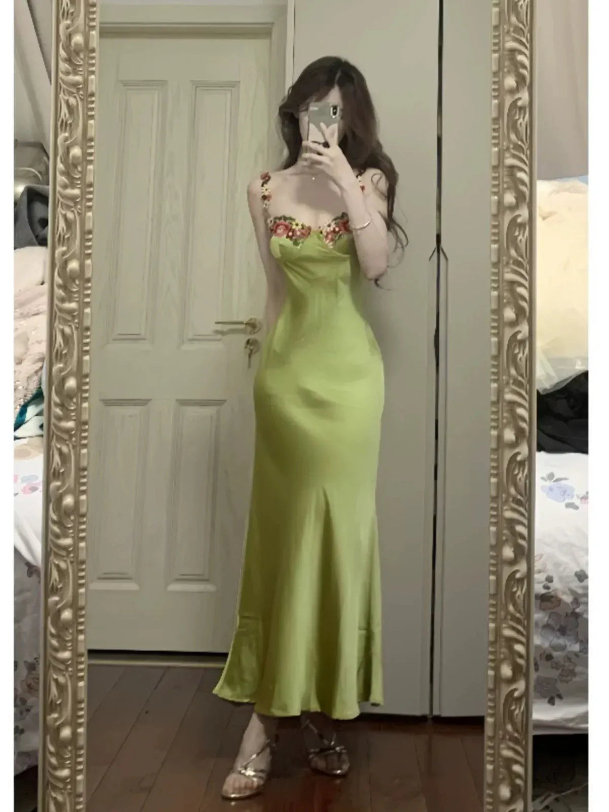 Close-up of the floral embroidery and sweetheart neckline on the sage green dress.