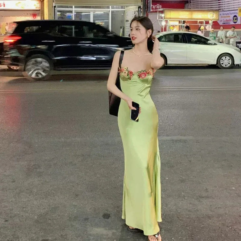 Texture and drape of the sage green satin dress material.