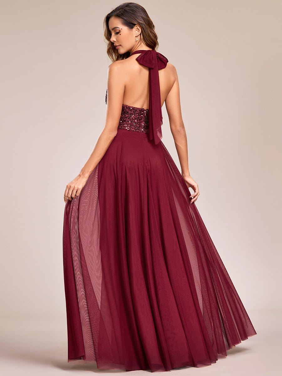 Model posing in a red sequin halter neck evening dress.