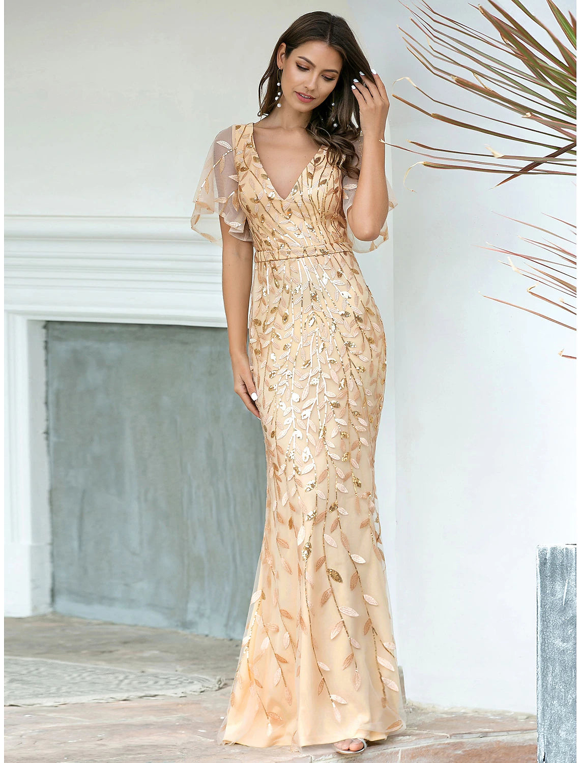 Back view of an elegant sequin mermaid trumpet gown with V-neck and short sleeves.