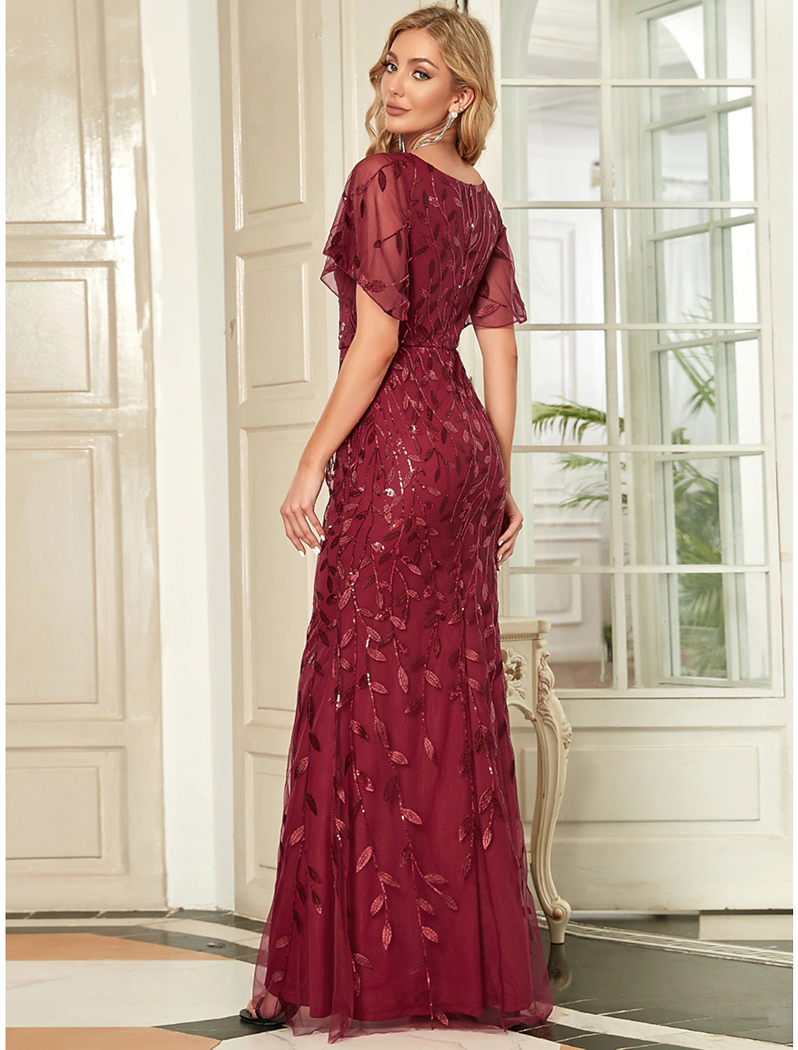 Full-length view of a model wearing the sequined mermaid trumpet evening gown.