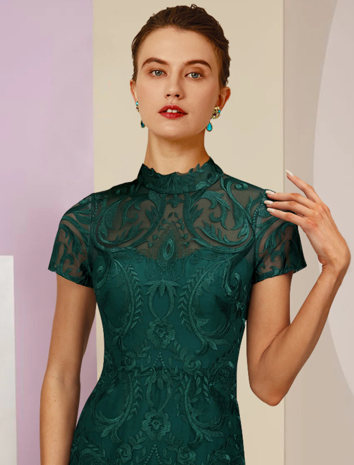 Back view of the high neck tea length dress, showing the column silhouette and appliques.