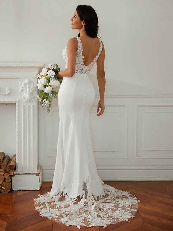 Back view of a bride in a lace V-neck wedding dress, showcasing the sweep train.