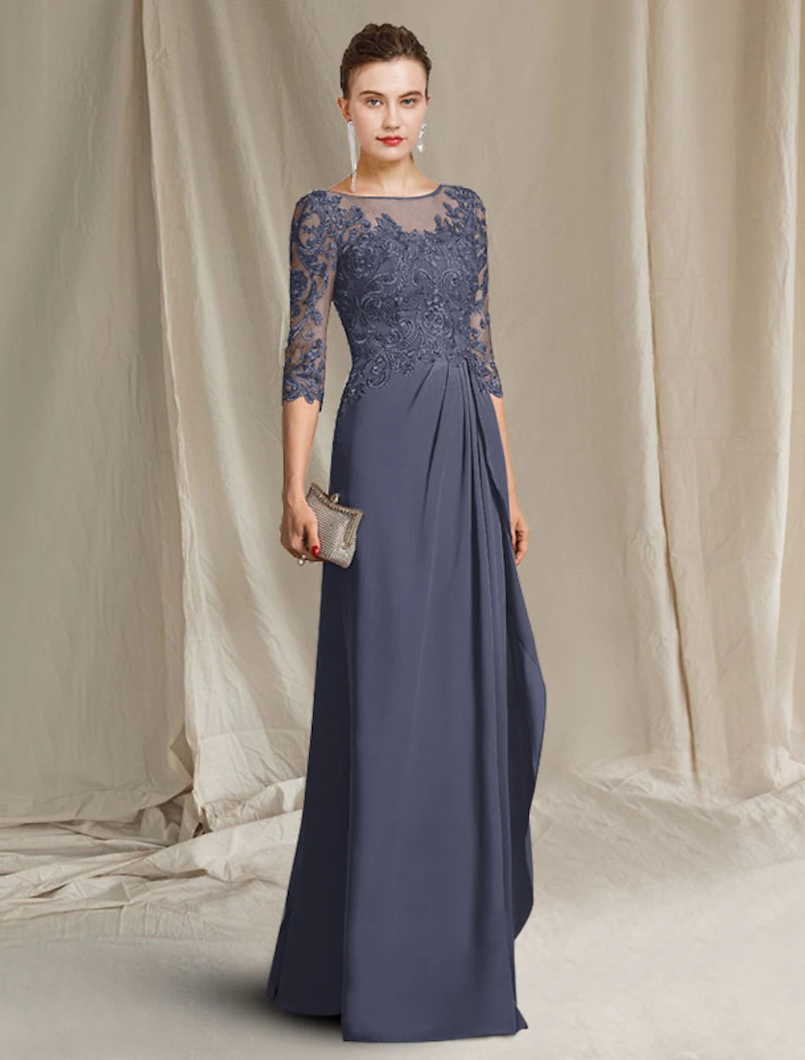 A woman wearing an elegant floor-length sheath column Mother of the Bride dress with a jewel neck and 3/4 lace sleeves.