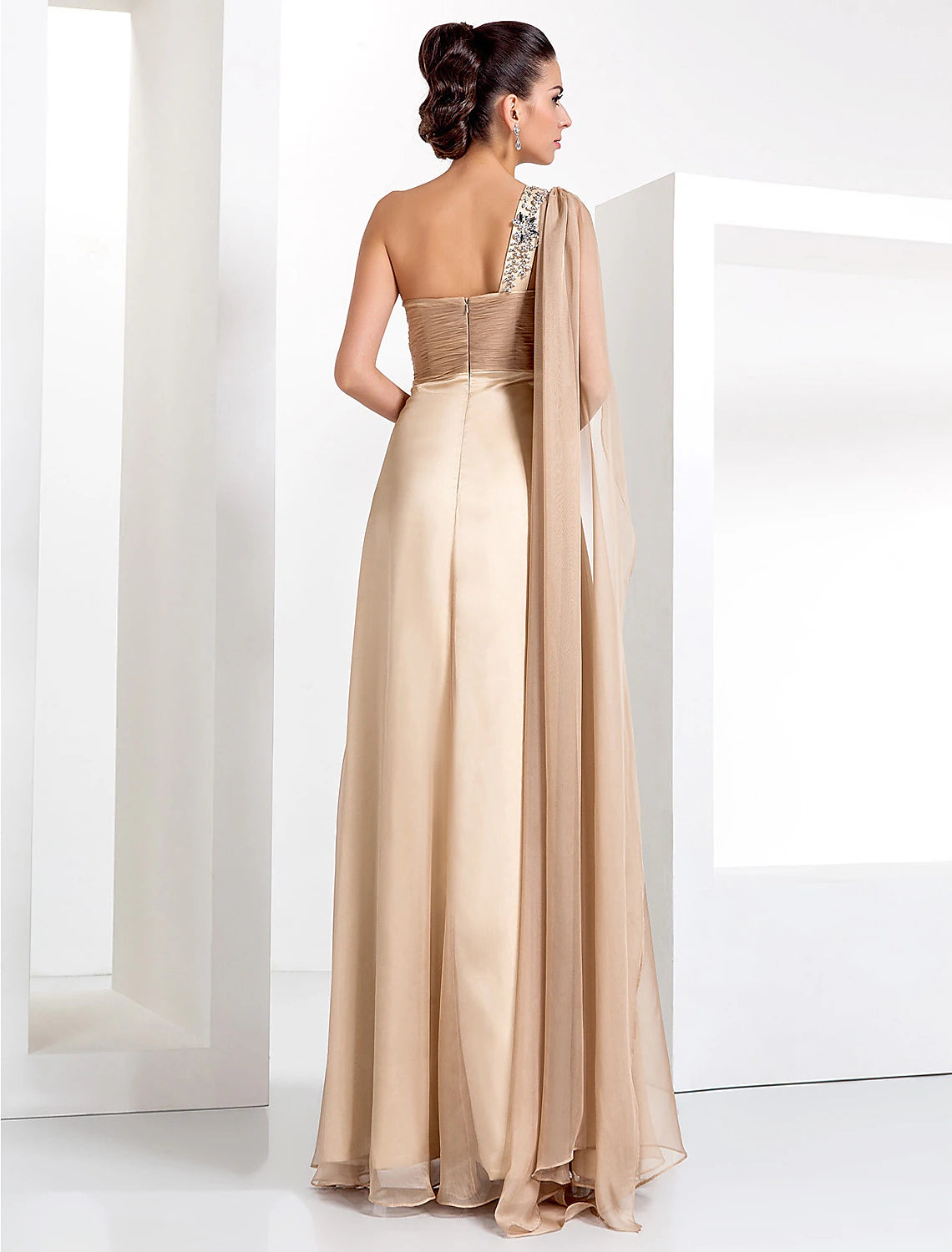 Close-up of the one-shoulder neckline and criss-cross crystal embellishments on the black gown.