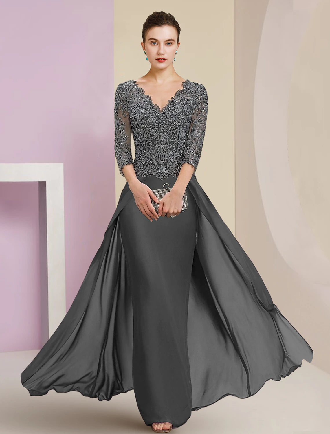Model wearing an elegant V-neck sheath column mother of the bride dress with 3/4 lace sleeves and appliques.