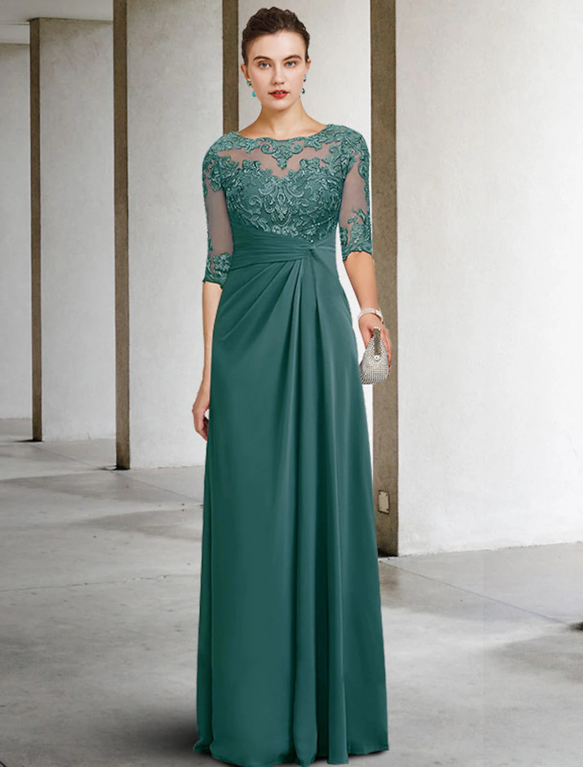 Model wearing an elegant blue sheath mother of the bride dress with jewel neck and short sleeves.